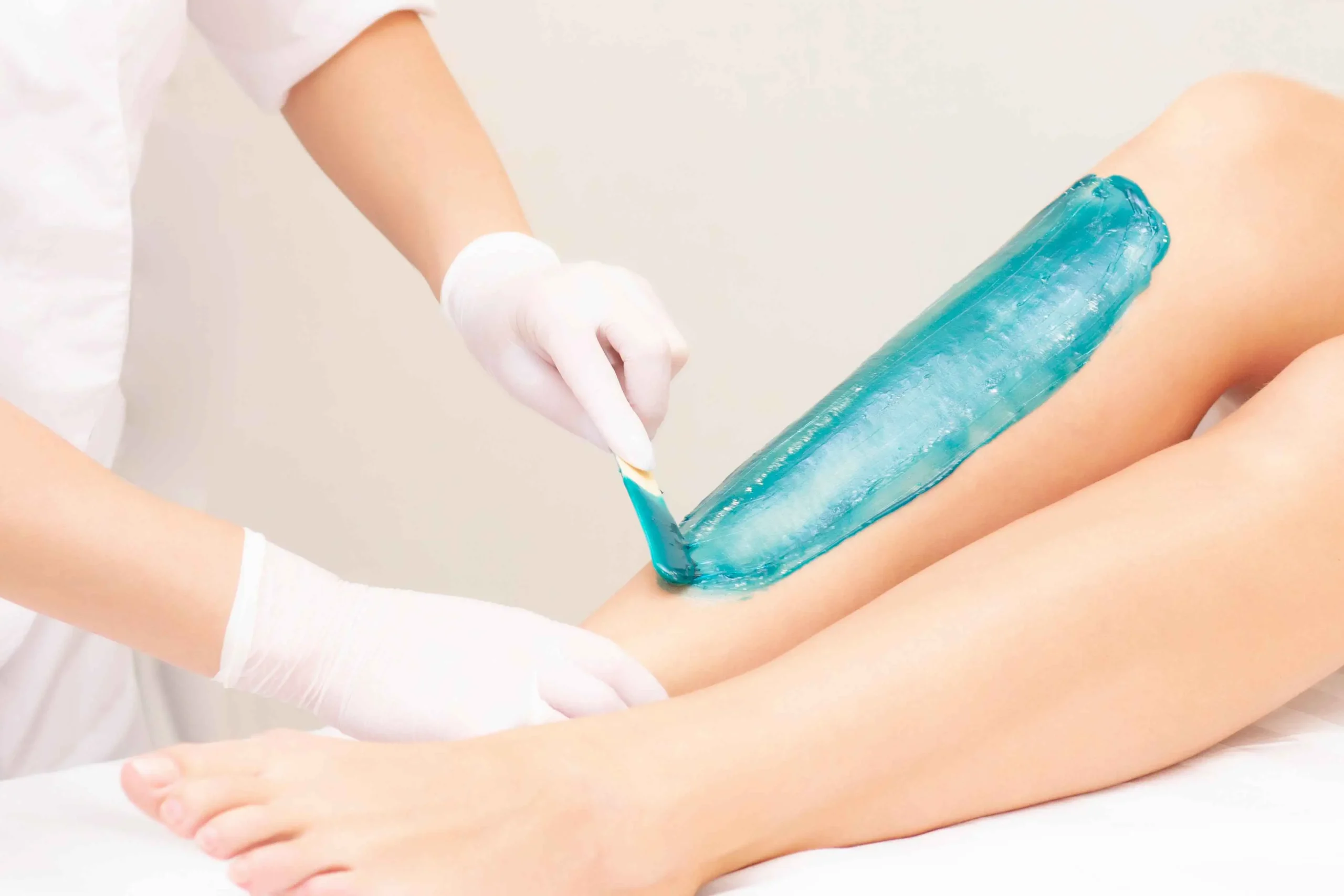 Depilazione Professionale con Ceretta: Pelle Liscia e Morbida per Lungo Tempo" Applicazione di ceretta professionale sulle gambe per una depilazione efficace e duratura.