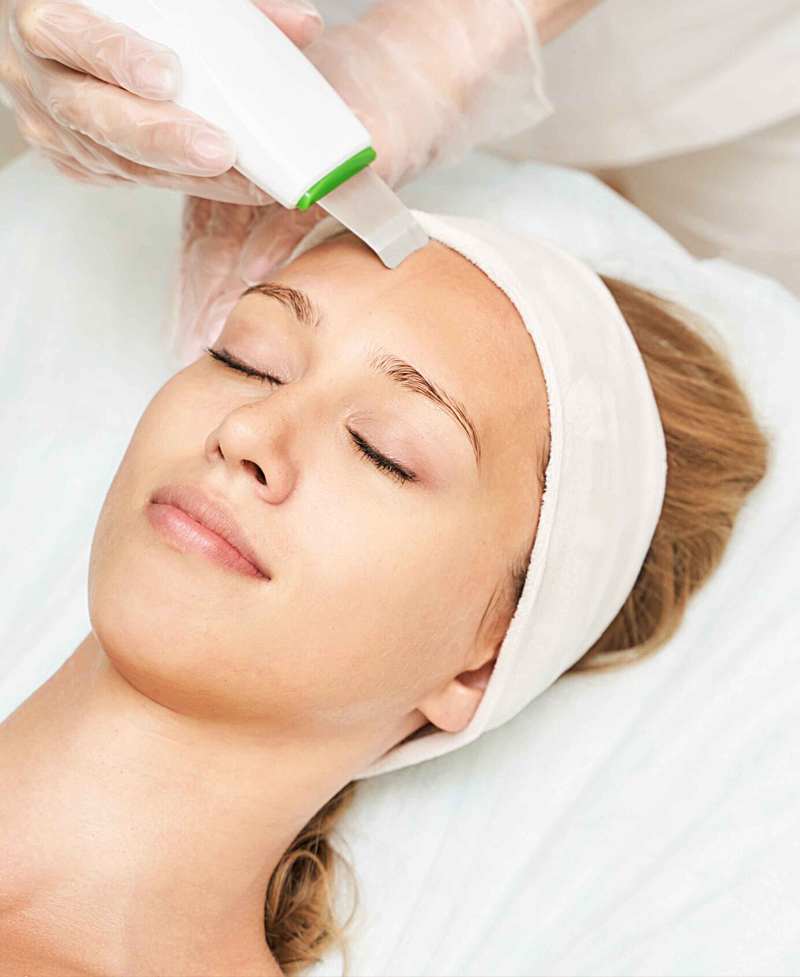 Trattamento di igiene viso profonda con apparecchio professionale ultrasuoni per una pelle pulita e luminosa."