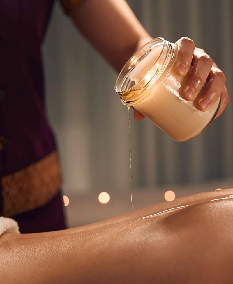 Applicazione di olio caldo durante un massaggio rilassante in un centro di bellezza